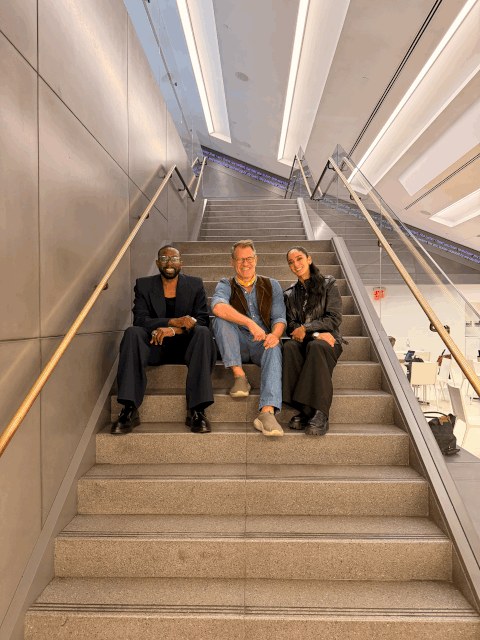 Three attendees seated on the staircase during the EMiLUX residency.