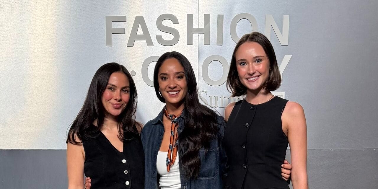 SPREEAI team members at the Fashionology Summit standing in front of the event signage